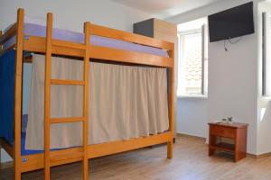 a bedroom with two bunk beds and a flat screen tv at Montenegro Backpackers Home Budva in Budva