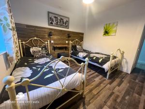 ein Zimmer mit zwei Betten und einem Tisch darin in der Unterkunft Howard Farm Holiday Cottages in Bude