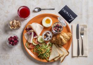 een bord met ontbijtproducten met een ei en toast bij Hotel Baltic in Rimini