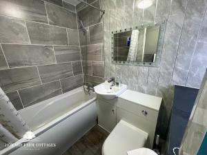 ein Badezimmer mit Waschbecken, Toilette und Badewanne in der Unterkunft Howard Farm Holiday Cottages in Bude + 33 Fotos