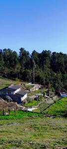 un campo con un edificio en medio de un campo en Casa do Monte, en Castro Daire