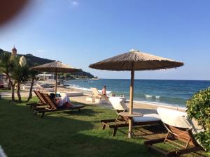 un gruppo di sedie e ombrelloni sulla spiaggia di ZEN Cozy Urban Ap in the heart of Zakynthos town a Città di Zante