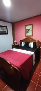 a bedroom with a large bed with a pink wall at Casa do Monte in Castro Daire