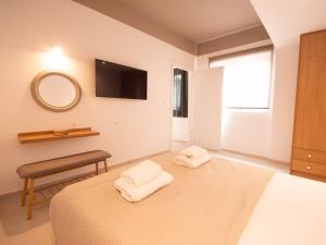 a bedroom with a bed and a mirror and a chair at STARI in Kattavía