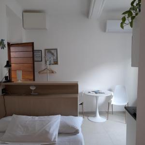 een slaapkamer met een bed, een tafel en een stoel bij Acla Apartments in Manarola