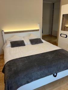 a large white bed with two pillows on it at Apartament Garbary 84 in Poznań