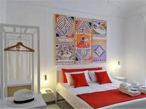 パレルモにあるCOLORI di PALERMOのベッドルーム1室(赤と白の枕が備わるベッド1台付)