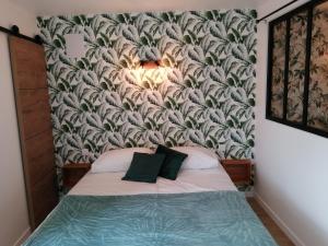 een slaapkamer met een bed met een muurschildering bij Chez Henri in Les Herbiers