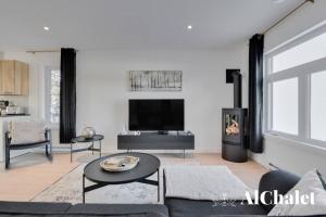 sala de estar con sofá y chimenea en Forêt Blanche - Sauna et Spa en Pont-Rouge