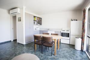 een keuken met een houten tafel en stoelen bij Apollo Lodge and Apartment in Wanaka