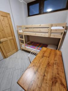 een kamer met een houten tafel en een stapelbed bij Ciasa de Leo in Mazzin