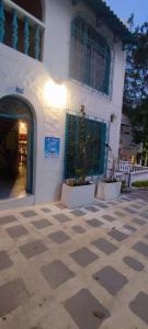 a white building with two potted plants in front of it at cabaña 61santorini colombiano in Doradal