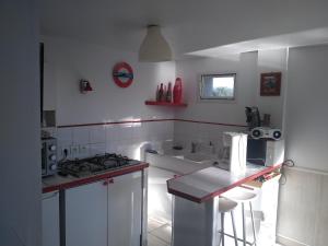 uma cozinha branca com um fogão e um lavatório em LA MADRAGUE- 2P avec piscine privative em Saint-Cyr-sur-Mer