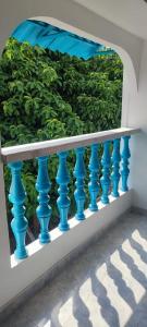 a blue railing in front of a green hedge at cabaña 61santorini colombiano in Doradal