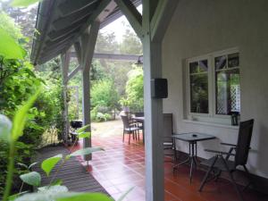 eine abgeschirmte Veranda mit einem Tisch und Stühlen in der Unterkunft Ferienhaus am Fleesensee in Silz