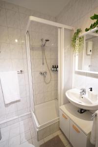 a white bathroom with a shower and a sink at Dein Flughafen Messe Apartment nahe Düsseldorf 2 in Duisburg