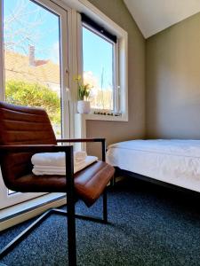 um quarto com uma cama, uma cadeira e uma janela em #26 Sokndal em Sokndal