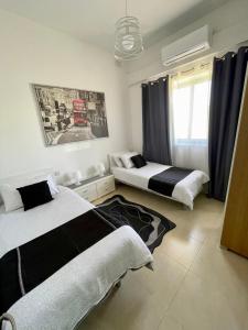 - une chambre avec 2 lits et une fenêtre dans l'établissement Park View, Maisonette 2, à San Pawl il-Baħar
