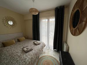 um quarto com uma cama e uma grande janela em Côté Jardin - Terrasse, Calme et Cosy em Deauville