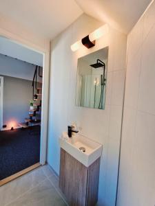 baño con lavabo y espejo en la pared en #26 Sokndal en Sokndal