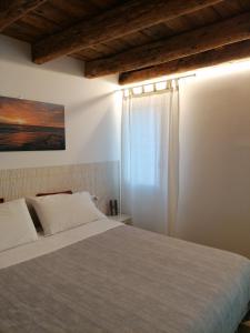 a bedroom with a large bed and a window at VERDEPOESIA in Chioggia
