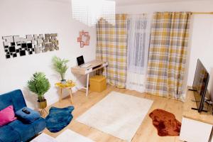 uma sala de estar com um sofá azul e uma secretária em Bakerville Stays - Home in Osier - 3 Bed em Nottingham