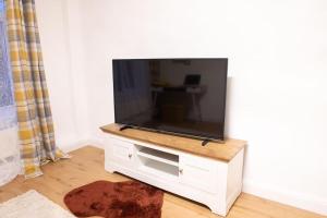 a flat screen tv sitting on top of a white cabinet at Bakerville Stays - Home in Osier - 3 Bed in Nottingham