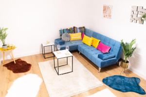 uma sala de estar com um sofá azul com almofadas coloridas em Bakerville Stays - Home in Osier - 3 Bed em Nottingham