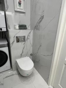 a bathroom with a white toilet and marble walls at D’AZUR-35 in Nice +18 photos