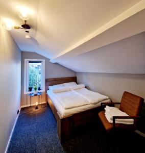 um quarto com uma cama, uma cadeira e uma janela em #26 Sokndal em Sokndal