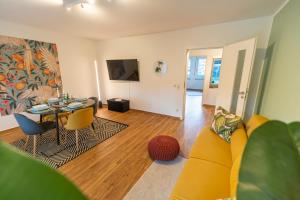 a living room with a yellow couch and a table at RR - Unique Apartment 70qm - Terrace - Washer in Magdeburg