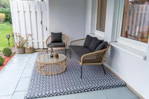 a porch with two wicker chairs and a table at RR - Unique Apartment 70qm - Terrace - Washer in Magdeburg