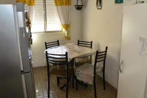 La cuisine est équipée d'une table, de chaises et d'un réfrigérateur. dans l'établissement Departamento en Jauregui (partido de Luján), à Luján