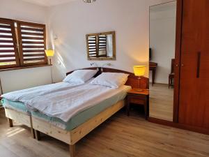 um quarto com uma cama com uma estrutura de madeira e 2 candeeiros em Natura Park w Stegnie em Stegna