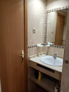 La salle de bains est pourvue d'un lavabo et d'un miroir. dans l'établissement ESTUDIO EDIFICIO LIMA-TORREMOLINOS, à Torremolinos