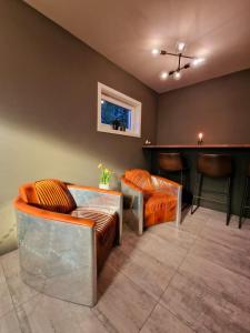 eine Bar mit orangefarbenen Stühlen und einer Theke in einem Zimmer in der Unterkunft #26 Sokndal in Sokndal