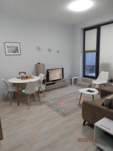 sala de estar con mesa y TV en Апартамент Нова Дружба 2, en Sofía