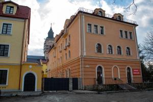 un gran edificio naranja con una torre de reloj en el fondo en Old Town Loft Apartments, en Kamianets-Podilskyi