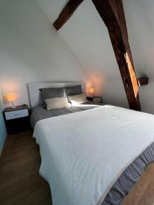 een slaapkamer met een wit bed en 2 nachtkastjes bij Gîte du Coudray 
