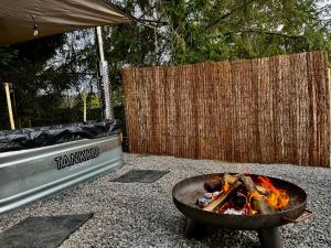 a fire pit sitting next to a fence at The Grey Tiny in Chimay