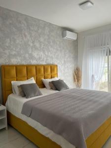 a bedroom with a large bed with a yellow headboard at River Luxury House in Bihać