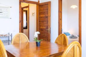 a dining room with a wooden table and chairs at Fronte Mare Pinus Village 76 in Santa Margherita di Pula