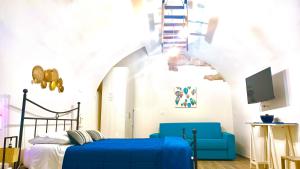 a bedroom with a blue bed and a tv at Antiche Mura Apartments"Nido di Puglia" monovano in Turi