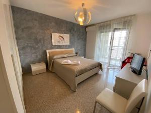 una camera con letto, sedia e televisore di Fronte Mare a Bari