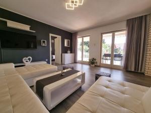 un soggiorno con due divani bianchi e una TV di Villa Ilaria a Bol Altre 37 foto