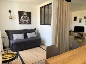 ein Wohnzimmer mit einem Sofa und einem Tisch in der Unterkunft Très bel appartement, port Sanary, in Sanary-sur-Mer