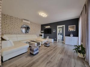 un soggiorno con mobili bianchi e un muro di mattoni di Villa Ilaria a Bol