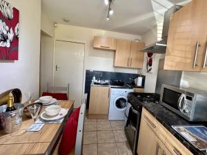a small kitchen with a table and a microwave at BOURNECOAST: LOVELY GROUND FLOOR STUDIO APARTMENT, NEAR RIVER & BEACHES - FM3001 in Iford