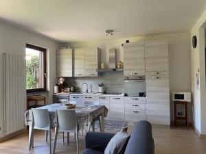 a kitchen with a table and a dining room at La casa del Conte - Feriolo di Baveno con giardino privato in Baveno
