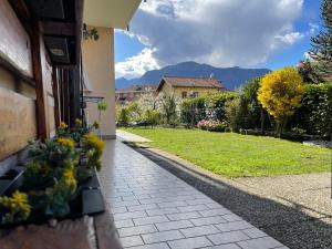 a walkway with flowers on the side of a house at La casa del Conte - Feriolo di Baveno con giardino privato in Baveno